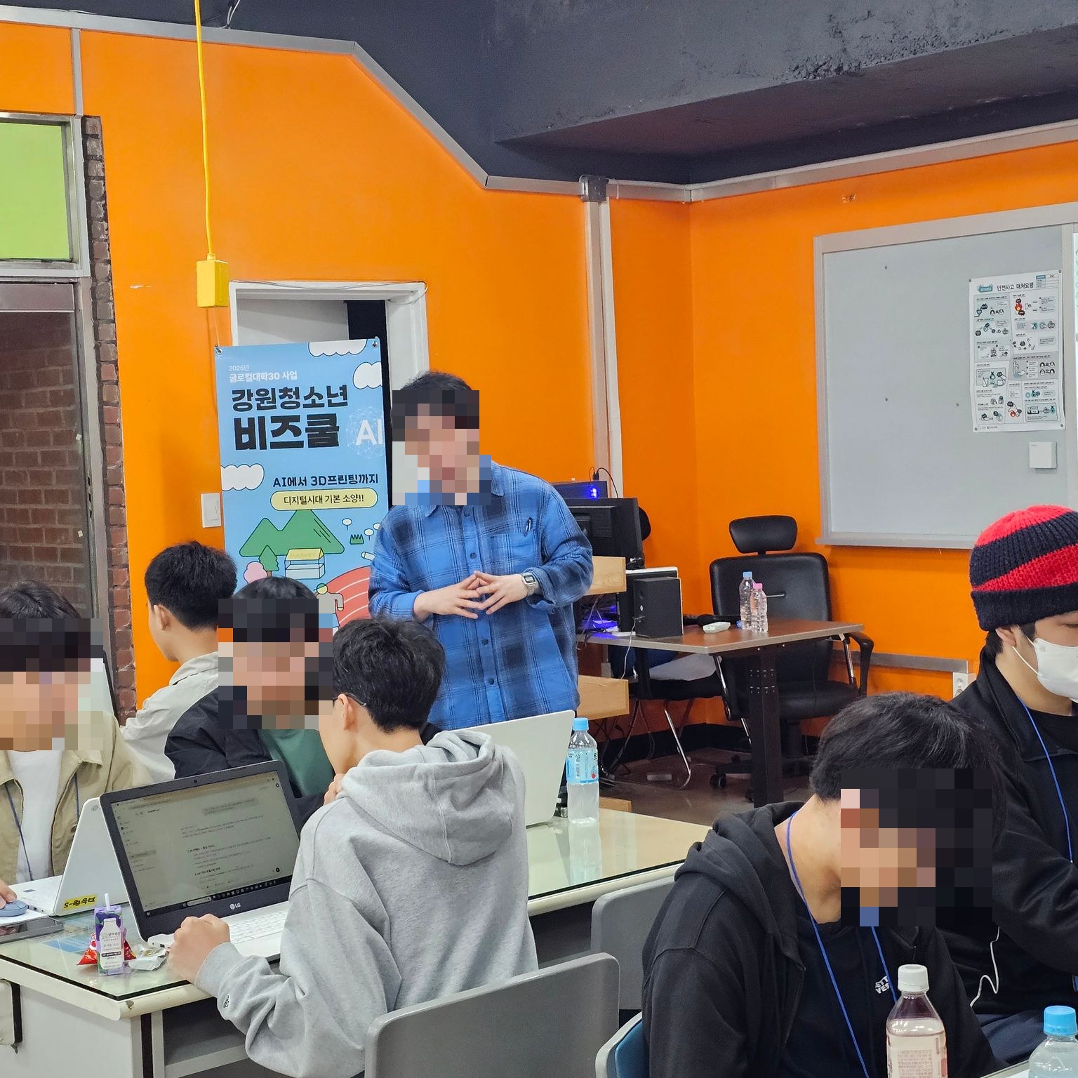 노트북으로 과제를 수행하는 학생들과 코칭하는 강사